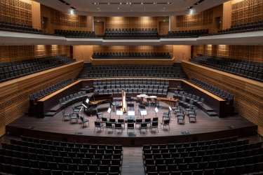 Central stage surrounded by terraced seats in Helsinki Music Centre auditorium